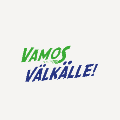 Logo, jossa lukee 'VAMOS VÄLKÄLLE!'. Sana 'VAMOS' on vihreällä ja kursiivilla, ja sana 'VÄLKÄLLE!' on sinisellä ja lihavoidulla isoilla kirjaimilla.
