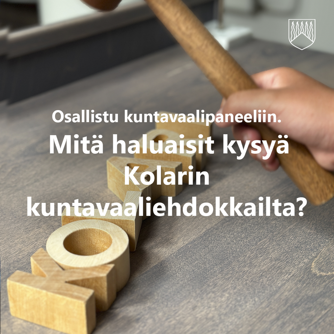 Kuvassa harmaalla puupöydällä puiset KOLARI-sanan kirjamet sekä lapsen käsi joka heiluttaa kunnanvaltuuston nuijaa.