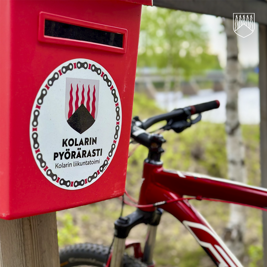 Punainen postilaatikko ja punainen polkupyörä.